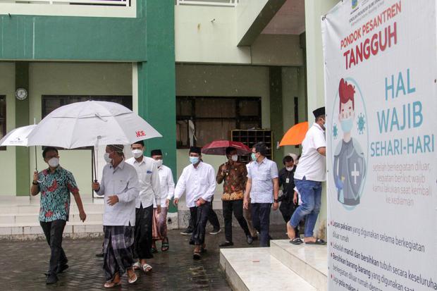 Menteri Kesehatan Budi Gunadi Sadikan (kiri) didampingi pengasuh Pondok Pesantren Bumi Sholawat KH Agoes Ali Mashuri (kedua kiri) di Lebo, Tulangan, Sidoarjo, Jawa Timur, Sabtu (27/2/2021).