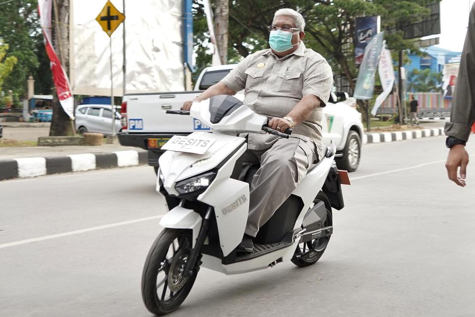 Gubernur Sulawesi Tenggara Ali Mazi (kiri) mengendarai sepeda motor listrik merk GESITS saat peluncuran di MTQ Square, Kendari, Sulawesi Tenggara, Sabtu (27/2/2021). PT WIKA Industri Manufaktur (WIMA) meluncurkan sepeda motor listrik berbasis baterai buat