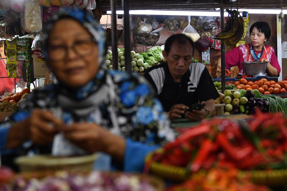 Pedagang sayuran menunggu calon pembeli di Pasar Pondok Labu, Jakarta Selatan, Senin (1/3/2021). Badan Pusat Statistik (BPS) mencatat kenaikan harga cabai rawit dan ikan segar menjadi pemicu terjadinya inflasi pada Februari 2021 sebesar 0,10 persen.