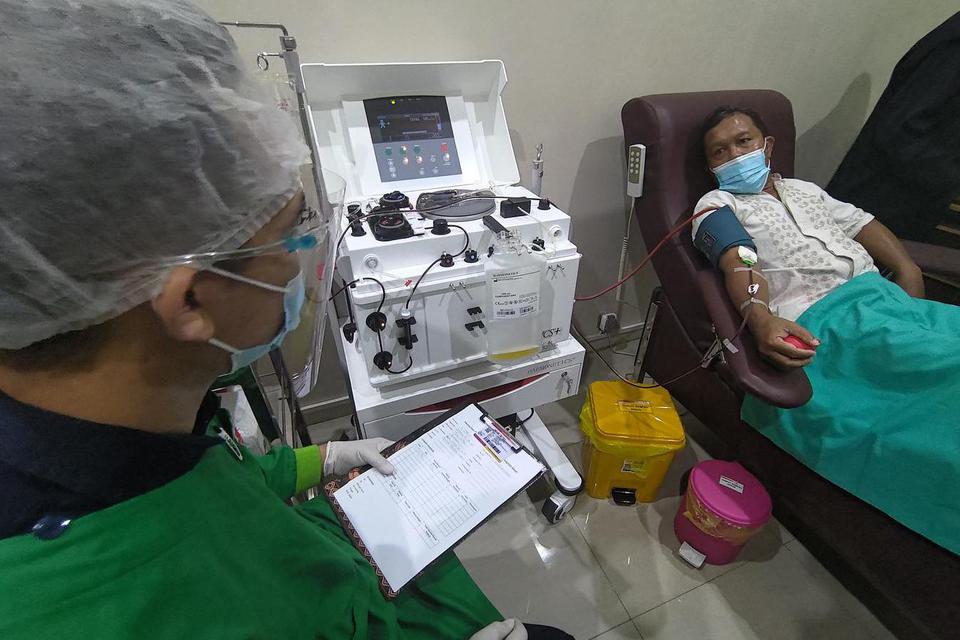 Petugas berinteraksi dengan penyintas COVID-19 yang mendonorkan plasma darahnya di UDD PMI Tulungagung, Tulungagung, Jawa Timur, Rabu (3/3/2021). Penyediaan sarana apherisis donor plasma itu untuk memenuhi tingginya kebutuhan plasma darah bagi penderita C