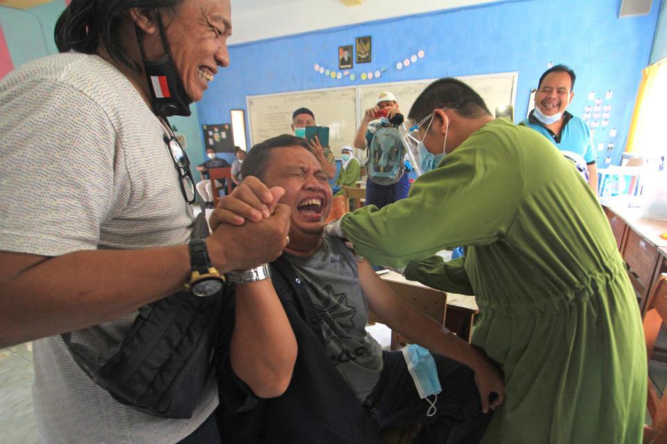 Seorang wartawan mengikuti vaksinasi COVID-19 di SMAN 1 Indramayu, Jawa Barat, Jumat (5/3/2021). Selain untuk petugas pelayanan publik, vaksinasi tersebut juga ditujukan untuk wartawan, atlet dan lansia.