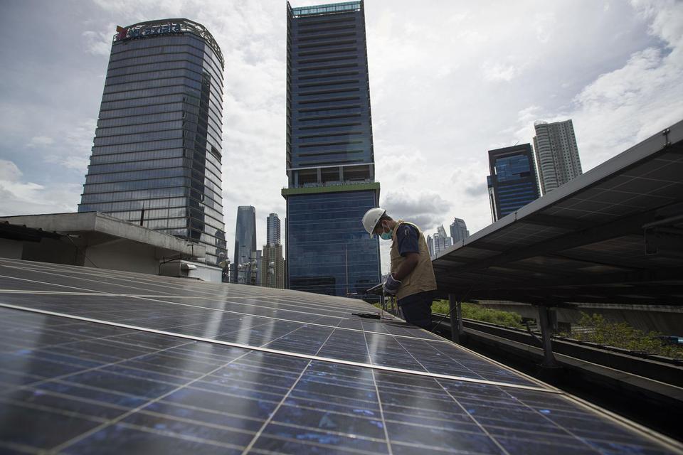 Petugas merawat panel surya yang terpasang di atap Gedung Direktorat Jenderal (Dirjen) Ketenagalistrikan Kementerian Energi dan Sumber Daya Mineral (EDSM), Jakarta, Rabu (24/3/2021). Kementerian ESDM hingga Maret 2021 telah membangun sebanyak 193 unit PLT