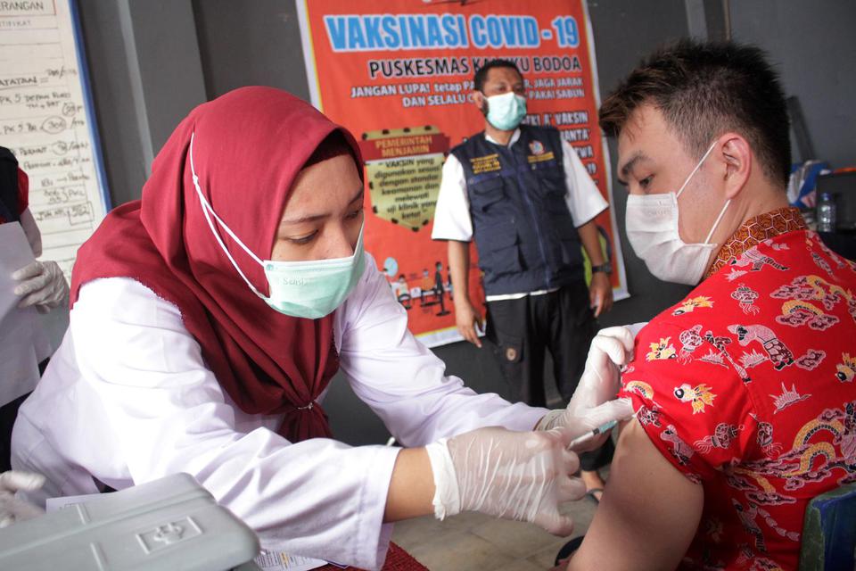 Pedagang pasar menerima suntikan vaksin COVID-19 di Pasar Pannampu, Makassar, Sulawesi Selatan, Rabu (24/3/2021). Tenaga medis yang bertugas mengatakan partisipasi pedagang pasar pada vaksinasi COVID-19 tersebut masih minim, tercatat sebanyak 103 pedagang