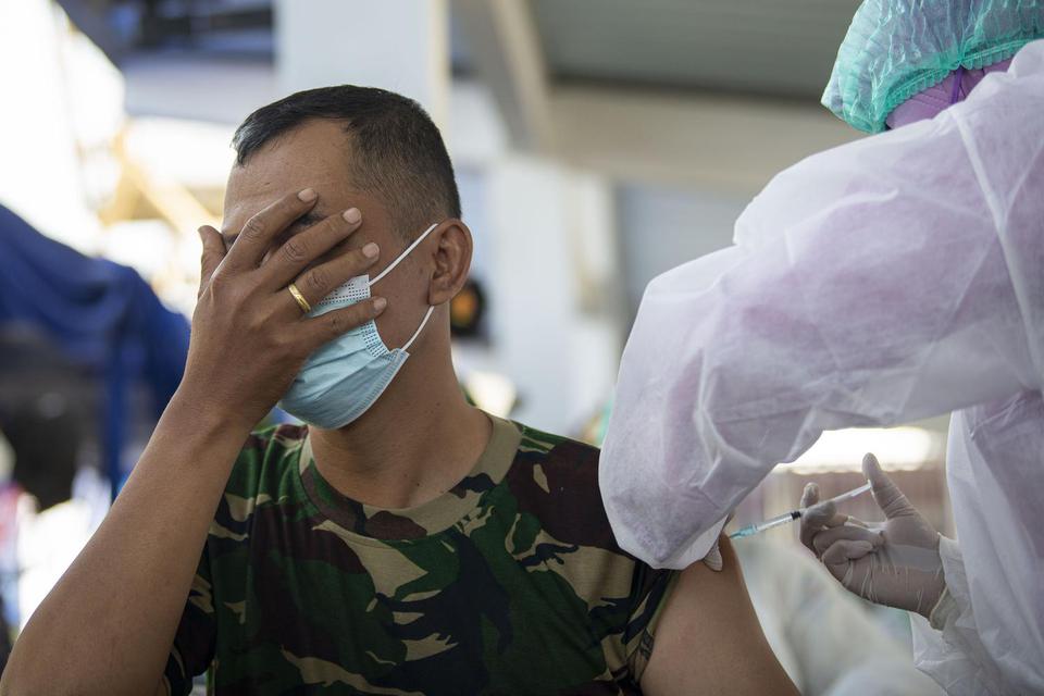 Prajurit TNI AL menutup matanya saat disuntik vaksin COVID-19 di Komando Lintas Laut Militer (Kolinlamil), Tanjung Priok, Jakarta, Kamis (24/3/2021). TNI AL melaksanakan "Penyapuan Vaksinasi COVID-19" terakhir kepada sekitar 5.000 prajurit di wilayah Ja