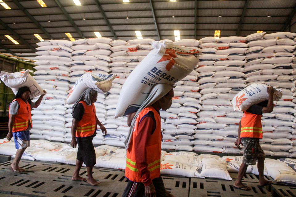 Pekerja mengangkut beras di Gudang Bulog Divre Jatim, Buduran, Sidoarjo, Jawa Timur, Kamis (25/3/2021). Meskipun pemerintah impor beras, Bulog Divre Jatim tetap melakukan penyerapan hasil panen petani di akhir bulan Maret dan pertengahan April dari 1.500