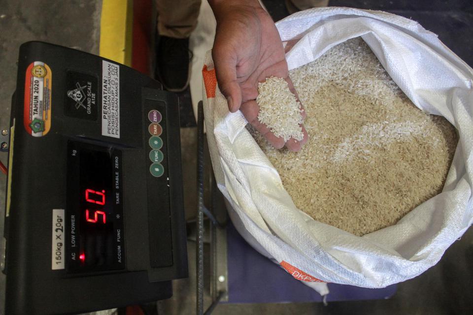 Pekerja menimbang beras di Gudang Bulog Divre Jatim, Buduran, Sidoarjo, Jawa Timur, Kamis (25/3/2021). 
