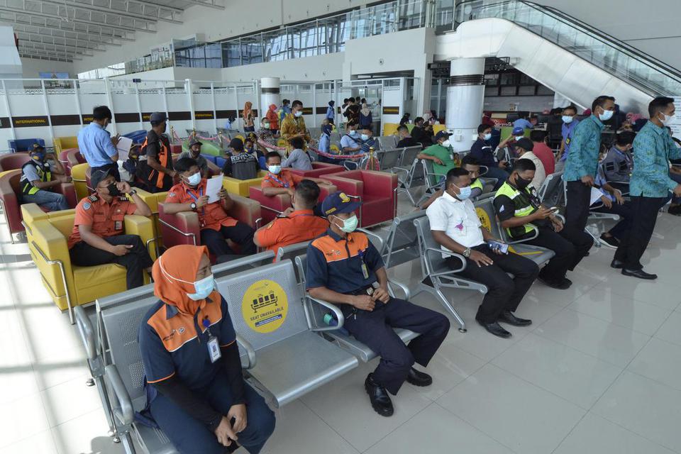 Pekerja bandara antre untuk mengikuti vaksinasi massal , di Bandara Radin Inten II Lampung Selatan, Lampung, Jumat (26/3/2021). Seperti tahun lalu, pemerintah kembali larang mudik lebaran 2021.