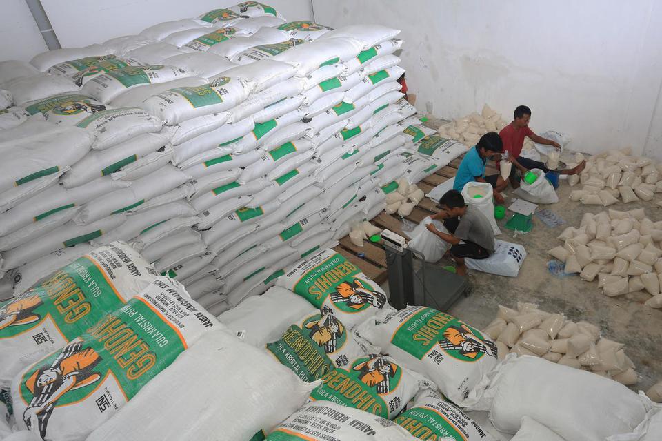 Pekerja menimbang dan mengemas gula pasir kiloan di Gudang Perum Bulog Meulaboh, Aceh Barat, Aceh, Jumat (2/4/2021). Kementerian Perdagangan menambahkan stok gula pasir impor untuk Pemerintah Aceh sebanyak 8.000 ton untuk memenuhi kebutuhan gula pasir sel