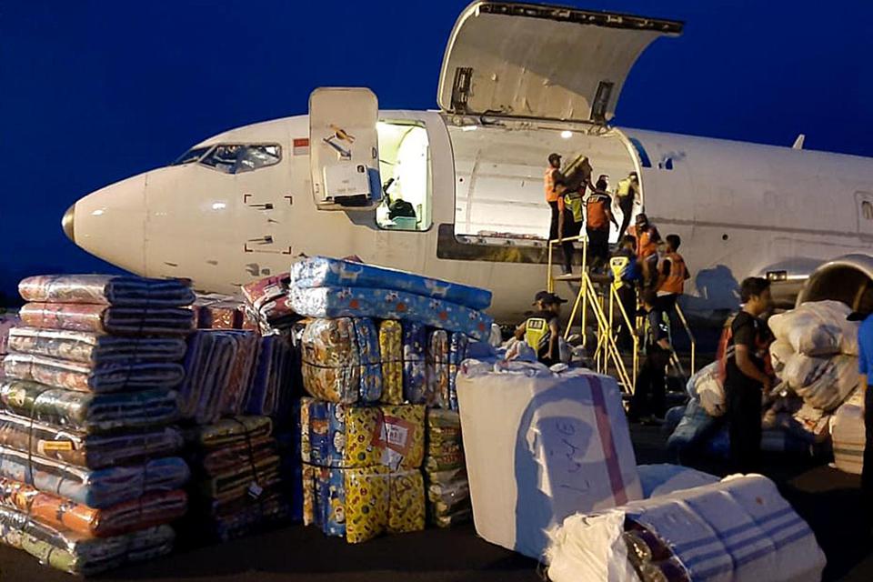 Pekerja membongkar muat bantuan logistik dari pesawat terbang di Bandara Frans Seda, Maumere, NTT, Senin (5/4/2021). Kementerian Sosial menyalurkan bantuan bagi korban banjir NTT.