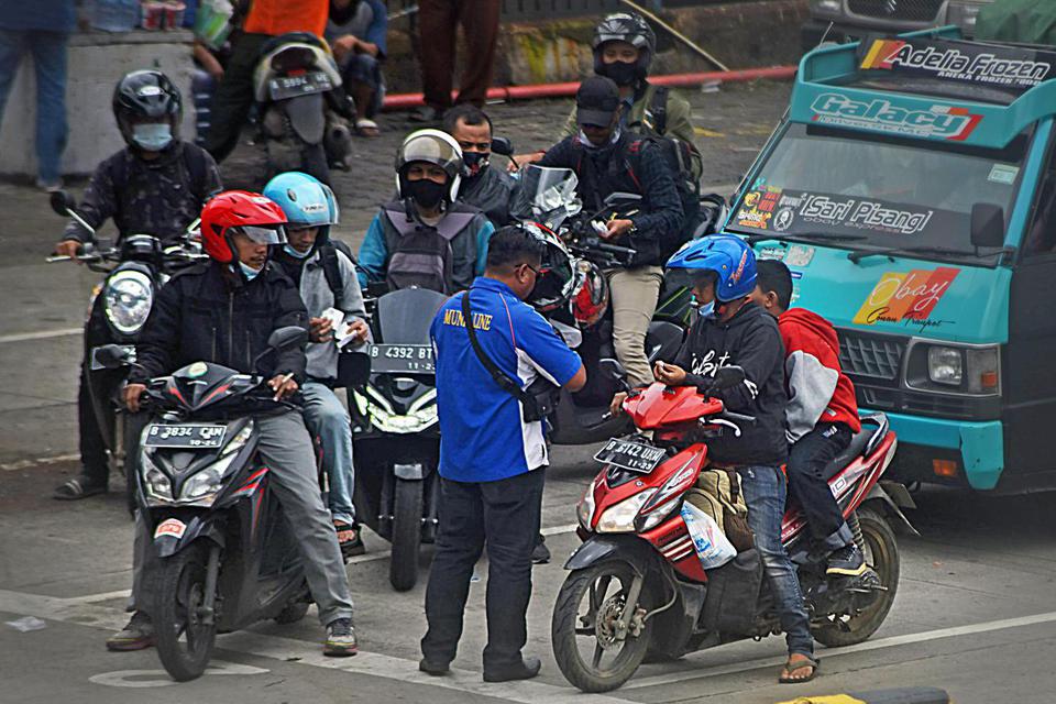 Petugas memeriksa tiket pengguna sepeda motor yang akan menyeberang ke Pulau Sumatera di Pelabuhan Merak, Banten, Sabtu (10/4/2021). Dirut PT ASDP Indonesia Ferry Ira Puspadewi menyatakan untuk mendukung kebijakan pemerintah tentang larangan mudik guna me