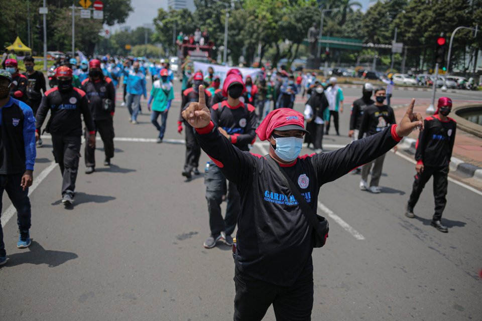 Sejumlah massa yang tergabung dalam Konfederasi Serikat Pekerja Indonesia (KSPI) menggelar aksi unduk rasa di kawasan Patung Kuda, Jakarta Pusat, Senin (12/4/2021). Para burun menuntut upah minimum sektoral kabupaten/kota (UMSK) 2021 tétap diberlakukan, s