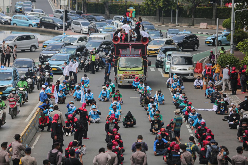 Sejumlah buruh menggelar aksi unduk rasa di kawasan Patung Kuda, Jakarta Pusat, Senin (12/4/2021). Mereka meminta pembayaran Tunjangan Hari Raya (THR) lebaran tidak lagi dicicil.