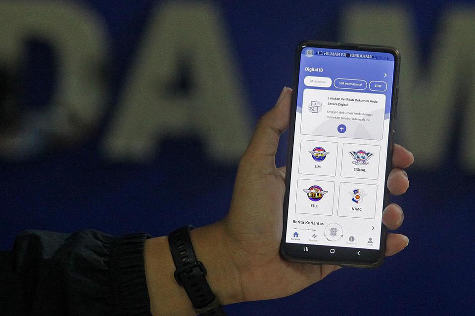 Petugas menunjukkan aplikasi SIM Nasional Presisi Korlantas Polri (Sinar) saat peluncurannya untuk guna perpanjangan SIM secara daring di Jakarta, Selasa (13/4/2021). Cara perpanjang SIM Online dilakukan menggunakan aplikasi Digital Korlantas Polri. Pemoh