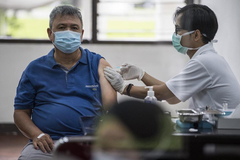 Vaksinator menyuntikkan vaksin COVID-19 kepada warga di Gedung Sate, Bandung, Jawa Barat, Rabu (14/4/2021). Pemerintah tetap melaksanakan vaksinasi selama bulan Ramadhan dengan berpedoman fatwa MUI tentang vaksinasi COVID-19 tidak membatalkan puasa.