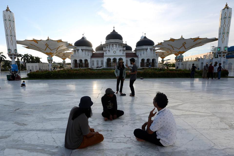 Ilustrasi, warga menikmati panorama Masjid Raya Baiturrahman sambil menunggu waktu untuk berbuka puasa (ngabuburit) di Banda Aceh, Aceh. Ada beberapa hal-hal yang membatalkan puasa, selain makan dan minum.