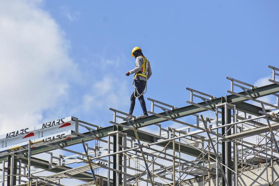 Seorang pekerja berjalan di rangka atap bangunan sebuah hotel di Mataram, NTB, Senin (19/4/2021). THR harus dibayarkan maksimal sepekan sebelum lebaran.