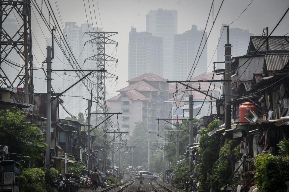 Deretan permukiman penduduk dengan latar belakang gedung bertingkat tersamar kabut polusi udara di Jakarta, Selasa (20/4/2021). Berdasarkan data "World Air Quality Index" pada Selasa (20/4) pukul 10.00 WIB tingkat polusi udara di Jakarta berada pada angka