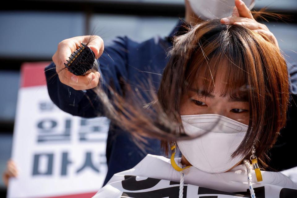 Kim Hong-ji Seorang mahasiswa Korea Selatan mencukur kepalanya t memprotes keputu Jepang untuk melepaskan air yang terkontaminasi dari pembangkit nuklir Fukushima yang lumpuh ke laut, di depan kedutaan Jepang, di Seoul, Korea Selatan.