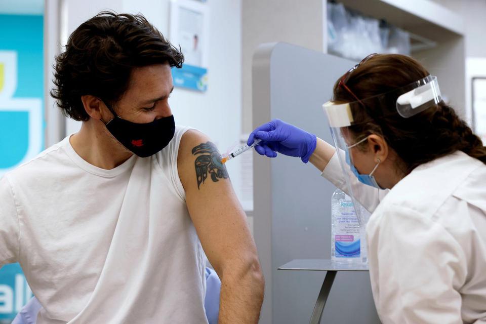 Blair Gable Perdana Menteri Kanada Justin Trudeau disuntik vaksin penyakit virus korona (COVID-19) AstraZeneca di sebuah apotek di Ottawa, Ontario, Kanada, Jumat (23/4/2021).