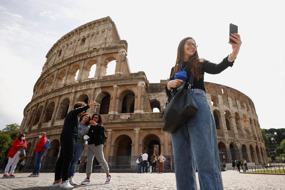 Guglielmo Mangiapane Warga melakukan swafoto di luar Colosseum pada hari pembukaan kembali, saat negara tersebut menjadi 'zona kuning', melonggarkan pembatasan penyakit virus korona (COVID-19), di Roma, Italia, Senin (26/4/2021). Italia akan mencabut a