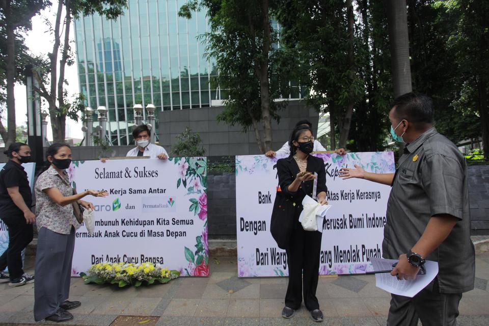 Anggota Gerakan Extinction Rebellion Indonesia menggelar aksi dengan mengirim karangan bunga di depan kantor Adaro, Jakarta, Senin (2/5/2021). Aksi tersebut ditujukan kepada sindikasi perbankan pemberi pinjaman dan Adaro sebagai tanda duka cita karena din