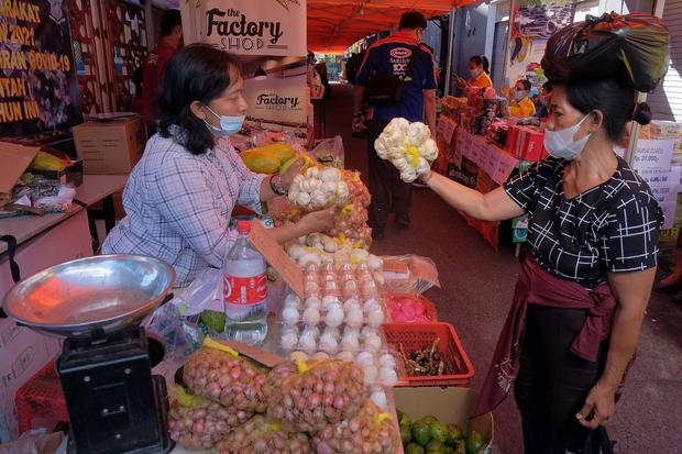 Pedagang melayani warga yang berbelanja saat pasar murah menjelang Hari Raya Idul Fitri 1442 Hijriah di Denpasar, Bali, Selasa (4/5/2021). Kegiatan yang digelar oleh Pemerintah Kota Denpasar pada 4-7 Mei 2021 tersebut untuk meringankan beban ekonomi masya