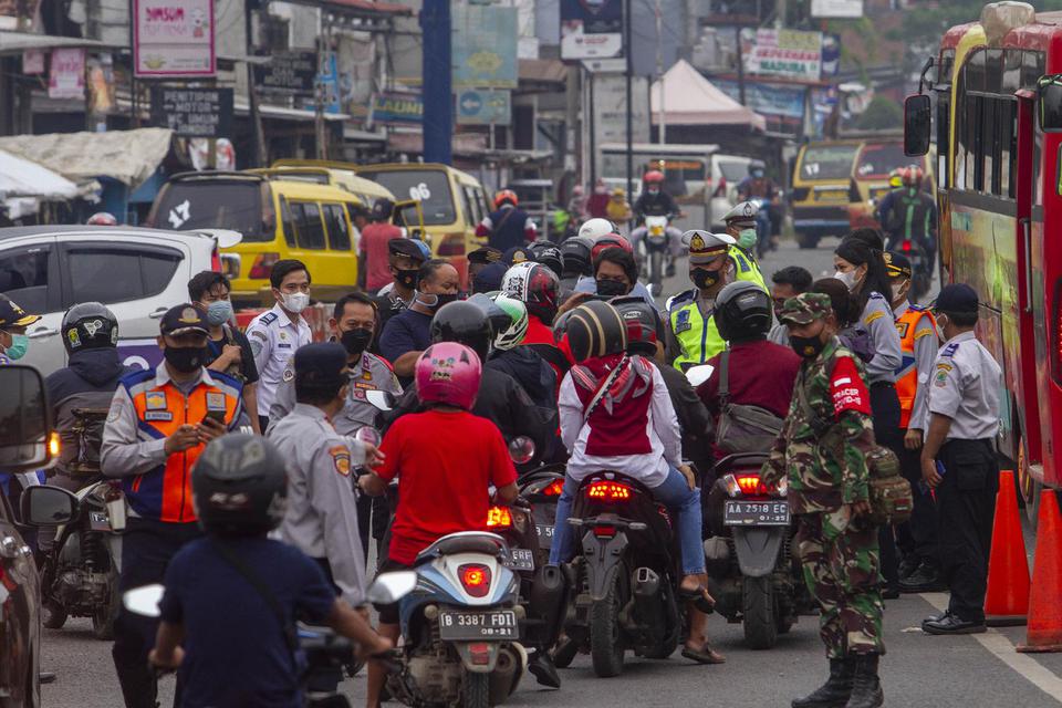 Petugas gabungan menghalau pemudik sepeda motor saat hari pertama penyekatan larangan mudik di Karawang, Jawa Barat, Kamis (6/5/2020). Penyekatan akses transportasi tersebut sebagai tindak lanjut kebijakan larangan mudik Lebaran pada 6 -17 Mei 2021 yang b