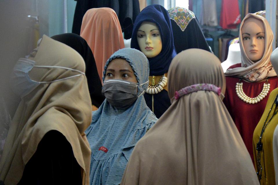Calon pembeli memilih busana muslim di Pasar Induk Minasa Maupa, Kabupaten Gowa, Sulawesi Selatan, Senin (10/5/2021). Meski masih dalam situasi pandemi, menurut pedagang di pasar tersebut penjualan busana muslim jelang Hari Raya Idul Fitri 1442 H mengalam
