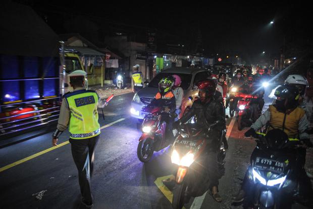 Petugas Kepolisian memutarbalikan kendaraan roda dua di posko penyakatan mudik Limbangan, Kabupaten Garut, Jawa Barat, Selasa (11/5/2021). Pada H-2 Idul Fitri 1442 H, petugas di posko penyekatan mudik Limbangan memutarbalikan ratusan pengendara roda dua y