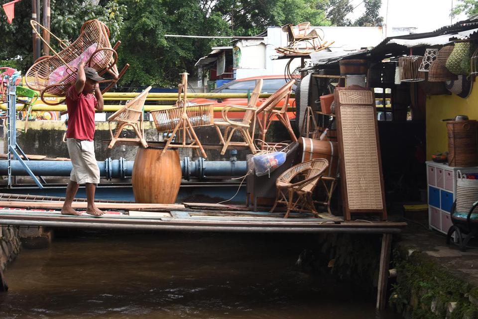 Perajin mengangkut tempat tidur bayi berbahan rotan pesanan pelanggan di kiosnya, Jakarta, Selasa (18/5/2021). Pemerintah mencatat realisasi anggaran Program Pemulihan Ekonomi Nasional (PEN) untuk UMKM dan korporasi hingga 11 Mei 2021 telah mencapai Rp42,