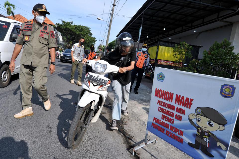 Petugas menghentikan pengendara yang tidak mengenakan masker saat sidak protokol kesehatan di kawasan Ubung, Denpasar, Bali, Rabu (19/5/2021). Sidak penerapan protokol kesehatan dalam Pemberlakuan Pembatasan Kegiatan Masyarakat (PPKM) Mikro tersebut terus