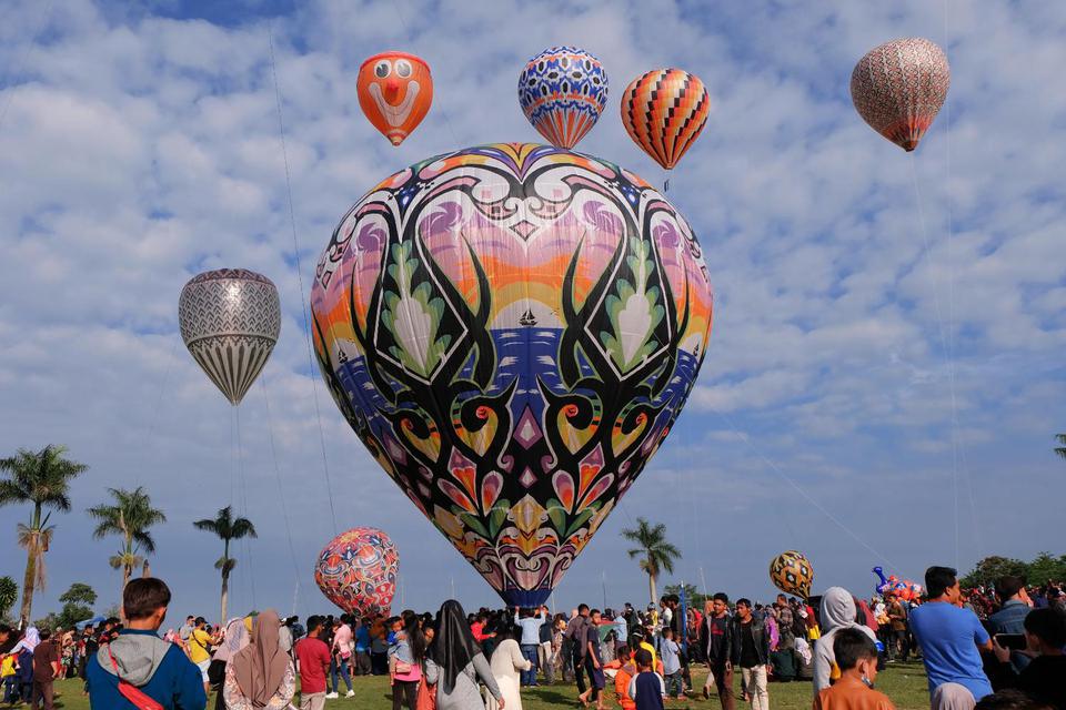 Sejumlah warga menyaksikan penerbangan balon udara di lapangan desa Kembaran, Kalikajar, Wonosobo, Jateng, Rabu (19/5/2021). Tradisi penerbangan balon udara tradisional rutin dilaksanakan masyarakat setempat pada hari ke tujuh Lebaran, agar tidak menggang
