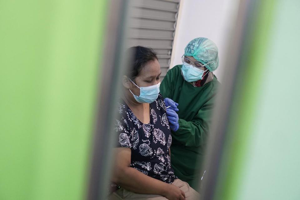 Petugas medis menyuntikan vaksin COVID-19 tahap kedua kepada pedagang di Pusat Grosir Solo (PGS), Solo, Jawa Tengah, Jumat (21/5/2021). Sebanyak 770 pedagang menerima vaksin tahap kedua untuk menekan penyebaran COVID-19 di pusat perbelanjaan sekaligus seb