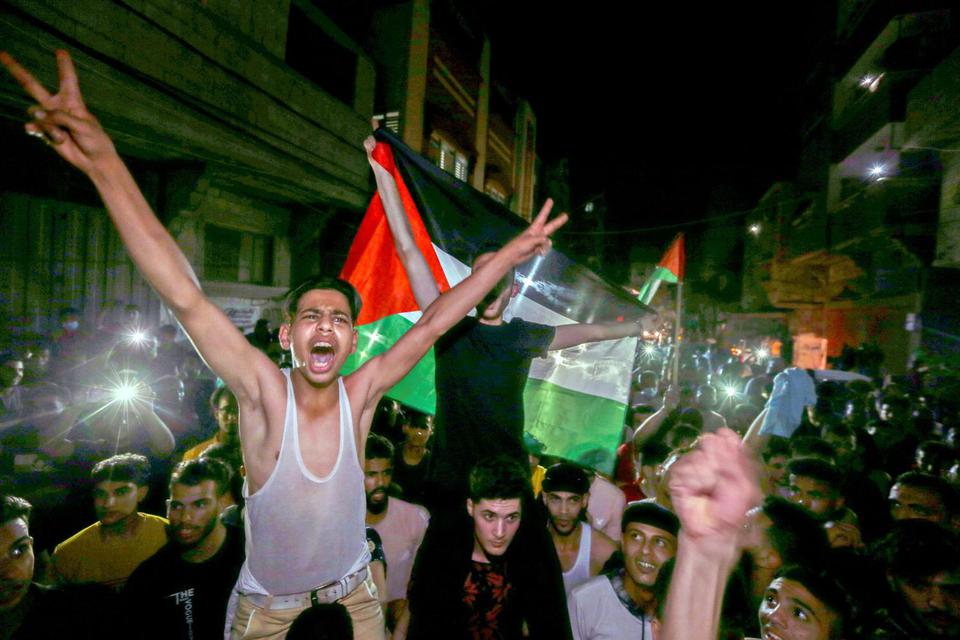 Ibraheem Abu Mustafa Warga Palestina merayakannya di jalan-jalan setelah gencatan senjata, di Jalur Gaza selatan, Jumat (21/5/2021).
