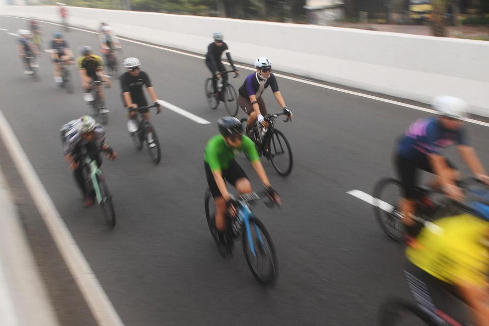 Sejumlah pesepeda memacu kecepatan saat berlangsungnya uji coba pemberlakuan lintasan road bike di jalan layang non tol (JLNT) Kampung Melayu-Tanah Abang, Jakarta, Minggu (23/5/2021). Kecepatan adalah konsep yang berkaitan dengan perpindahan besar dalam w