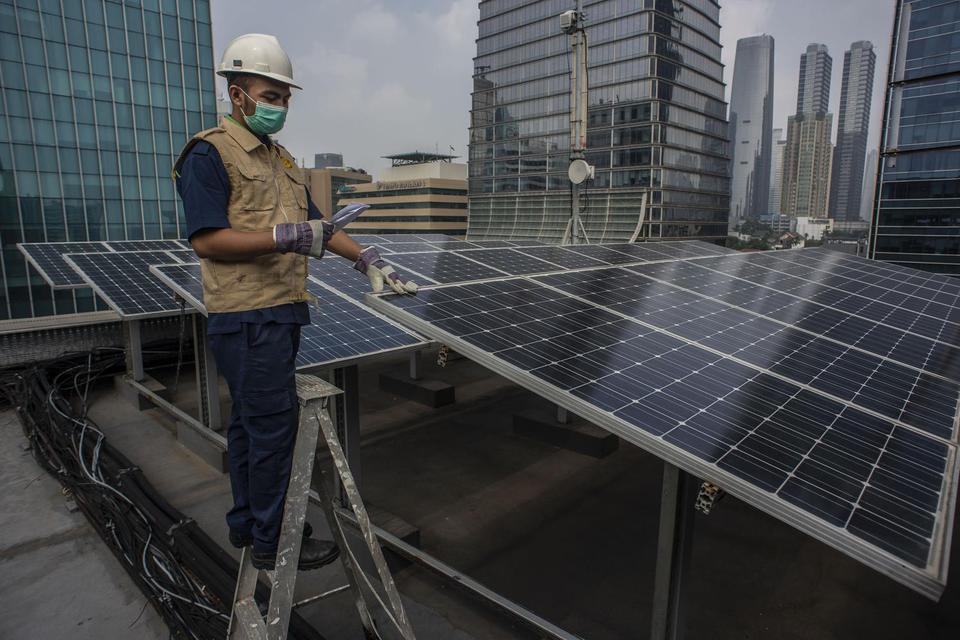 Petugas merawat panel surya yang terpasang di atap Gedung Direktorat Jenderal (Dirjen) Ketenagalistrikan Kementerian Energi dan Sumber Daya Mineral (EDSM), Jakarta, Senin (24/5/2021). Kementerian Energi dan Sumber Daya Mineral (ESDM) menyebutkan bahwa pen