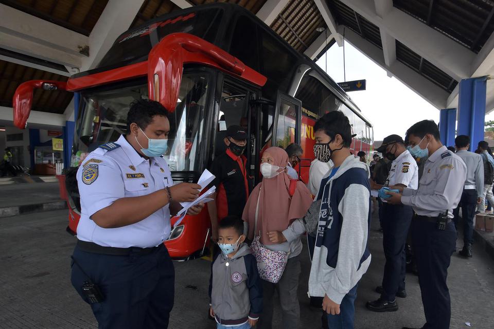 Petugas memeriksa surat keterangan sehat bebas COVID-19 milik penumpang bus saat pengetatan arus balik Lebaran di Terminal Tipe A Mengwi, Badung, Bali, Senin (24/5/2021). Kegiatan pengetatan arus balik Lebaran yang dimulai pada 18-24 Mei 2021 di terminal 