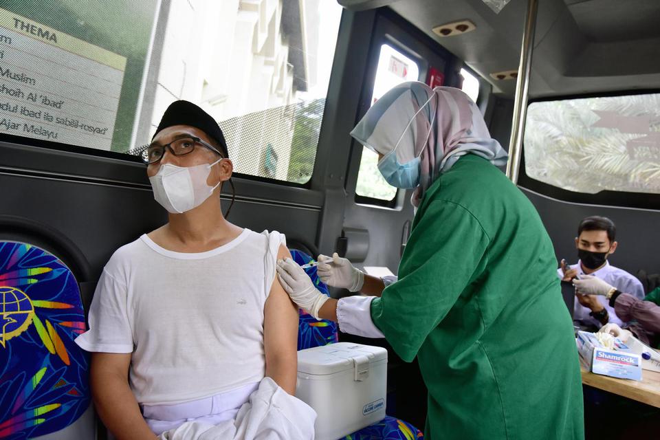 Sejumlah warga mendapatkan vaksinasi di dalam bus Trans Metro Pekanbaru untuk vaksinasi COVID-19 di Kota Pekanbaru, Riau, Jumat (28/5/2021). Pemerintah Kota Pekanbaru mengubah lima bus trans metro menjadi layanan vaksinasi keliling untuk menjemput bola ke