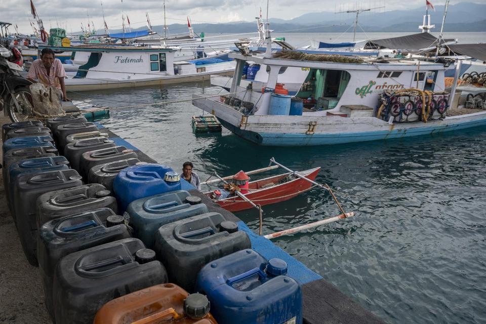 Pekerja menurunkan BBM jenis solar ke kapal nelayan di Pelabuhan Pendaratan Ikan (PPI) Donggala, Sulawesi Tengah, Selasa (1/6/2021). Pemerintah melalui Kementerian ESDM akan mengonversi penggunaan bahan bakar minyak (BBM) ke bahan bakar gas (BBG) kepada 