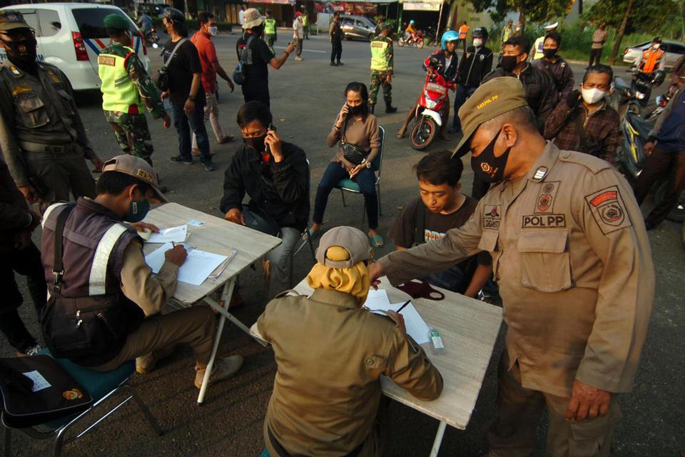 Petugas Satpol PP mendata warga yang tidak memakai masker saat razia masker di Slawi, Kabupaten Tegal, Jawa Tengah, Rabu (2/6/2021).