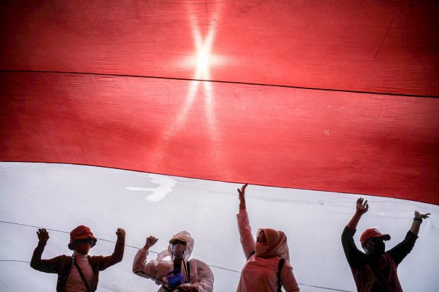 Sejumlah relawan yang tergabung dalam Gerakan Jaga Indonesia (GJI) mengibarkan bendera merah putih raksasa di Patung Kuda, Jalan Merdeka Barat, Jakarta Pusat, Rabu (2/6/2021). Warga negara adalah warga suatu negara yang ditetapkan berdasarkan peraturan pe