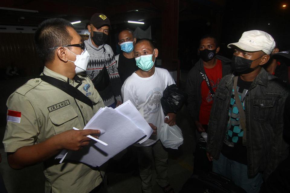 Petugas BP2MI Pontianak mendata sejumlah Pekerja Migran Indonesia (PMI) sebelum keberangkatan di Pelabuhan Dwikora Pontianak, Kalimantan Barat, Rabu (2/6/2021) malam. Sebanyak 47 PMI dan tiga anak yang dideportasi Malaysia pada Rabu (26/5/2021) diberangka