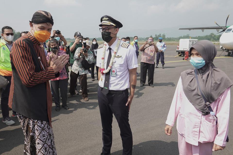 Gubernur Jateng Ganjar Pranowo (kiri), menyambut pilot maskapai penerbangan Citilink yang mendarat dari Surabaya di Bandara Jenderal Besar Soedirman (JBS), Purbalingga, Jawa Tengah, Kamis (3/6/2021). Sebanyak 24 penumpang mendarat dari Surabaya dan 37 pen