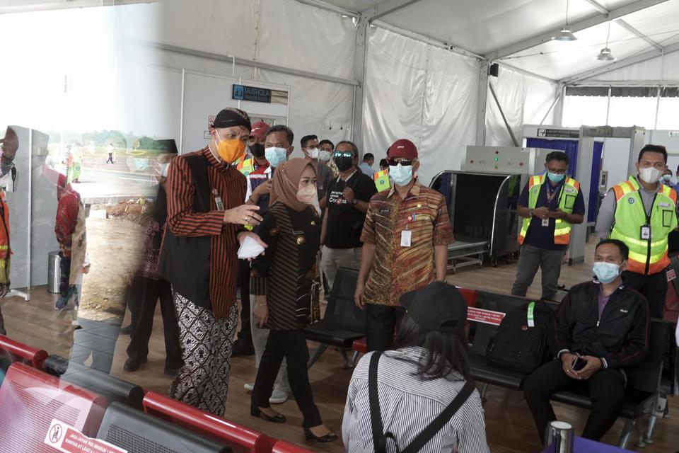 Gubernur Jateng Ganjar Pranowo (kiri), berbincang dengan penumpang penerbangan komersial perdana di ruang tunggu terminal keberangkatan Bandara Jenderal Besar Soedirman (JBS), Purbalingga, Jawa Tengah, Kamis (3/6/2021). Sebanyak 24 penumpang mendarat dari