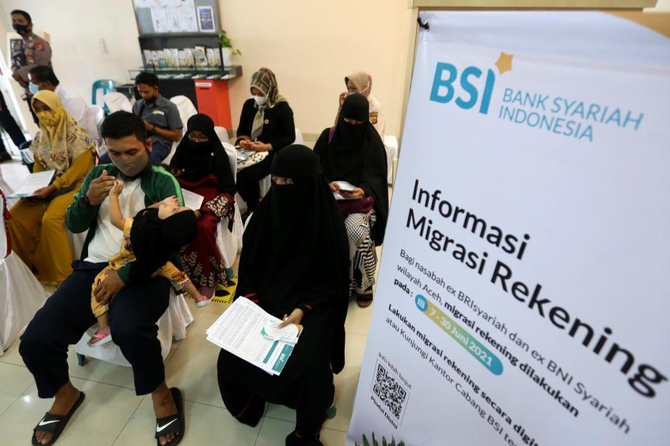 Nasabah antre melakukan migrasi rekening di Bank Syariah Indonesia (BSI) di Banda Aceh, Aceh, Senin (7/6/2021). Pandemi meningkatkan tren hijrah ke perbankan Syariah.