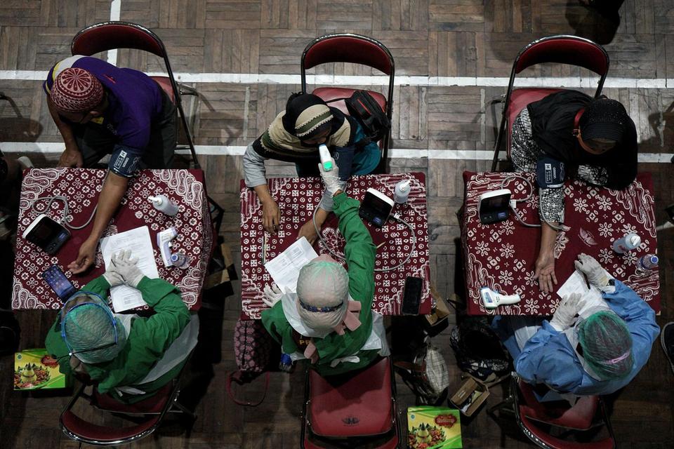 Petugas melakukan skrining kesehatan peserta saat vaksinasi COVID-19 massal untuk pedagang pasar tradisional di GOR Pangukan, Sleman, D.I Yogyakarta, Rabu (9/6/2021). Indonesia akan mendapatkan bantuan vaksin Oxford-AstraZeneca dari Pemerintah Inggris.