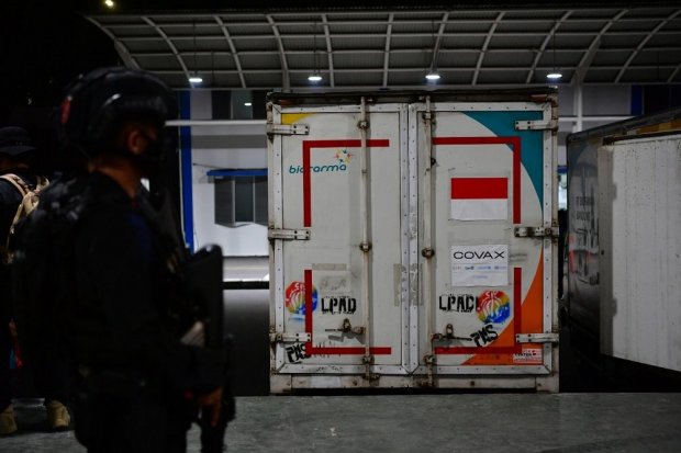 Seorang anggota Polri bersenjata tampak berjaga-jaga didepan kontainer vaksin AstraZeneca yang baru saja tiba di Bandara Internasional Soekarno-Hatta pada Kamis (10/6). Indonesia Kembali menerima tambahan 1.500.800 dosis vaksin AstraZeneca, setelah sebelu