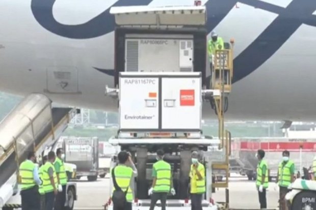 Para petugas Bandara Internasional Soekarno-Hatta sedang mengawasi proses penurunan kontainer berisi bahan baku Sinovac pada Minggu (20/6). (www.sehatnegeriku.kemkes.go.id)