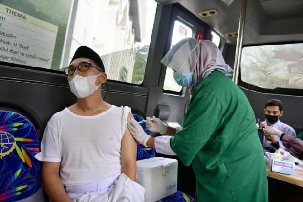Sejumlah warga mendapatkan vaksinasi di dalam bus Trans Metro Pekanbaru untuk vaksinasi Covid-19 di Kota Pekanbaru, Riau, Jumat (28/5/2021) (Antara Foto/B. Anggoro)