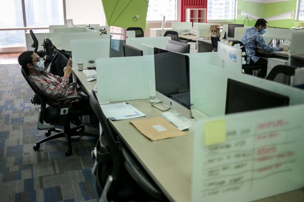 Sejumlah pekerja beraktivitas di ruang kerja di masa Penerapan Pembatasan Kegiatan Masyarakat (PPKM) Darurat di kantor perbankan wilayah Sudirman Central Business District (SCBD), Senayan, Kebayoran Baru, Jakarta Selatan, Senin, (5/7/2021). Pemprov DKI Ja